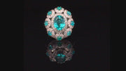 Video of rotating platinum ring with a faceted African paraiba, Brazilian cabochon paraibas, and diamonds on a black background