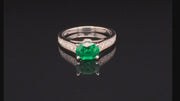 Video of rotating platinum ring  with oval emerald and diamonds on black background