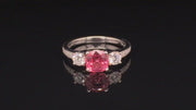 Video of rotating platinum ring with pink-orange spinel and diamonds on black background