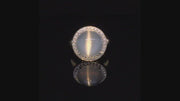 Video of rotating ring with blue gray gemstone and diamonds on black background