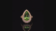Video of rotating ring with light green gemstone and diamonds on black background