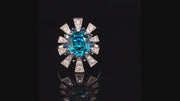 Video of rotating 18K white gold ring featuring a blue zircon surrounded by a starburst motif of blue sapphires and brilliant diamonds on a black background.