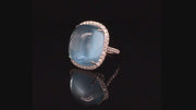 Video of rotating 18K white gold ring featuring a large aquamarine cabochon with a diamond halo on black background