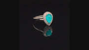 Video of rotating platinum ring with a pear-shape Brazilian paraiba cabochon and pave diamonds on black background.