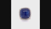 Video of rotating 18K white gold ring with a cushion cabochon tanzanite with a diamond halo on a white background