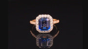 Video of rotating emerald-cut sapphire set in platinum and surrounded by diamonds with an 18K yellow gold band with diamonds on a black background.