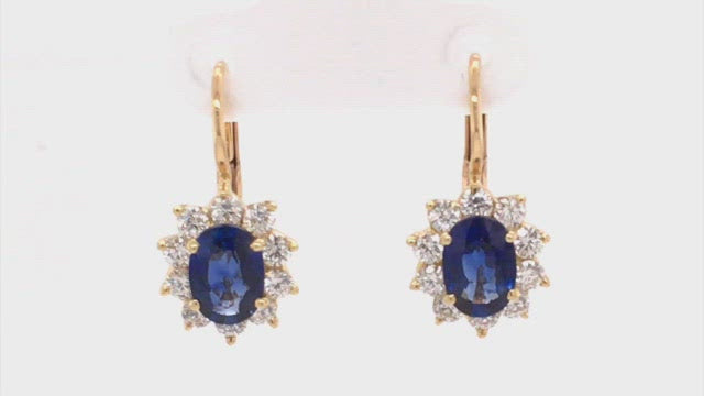 Video of rotating earrings with blue gemstones and diamonds on white background