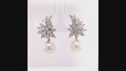 Video of rotating pearl earrings with a platinum cluster with marquise, pear-shaped, and brilliant-cut diamonds on a white background