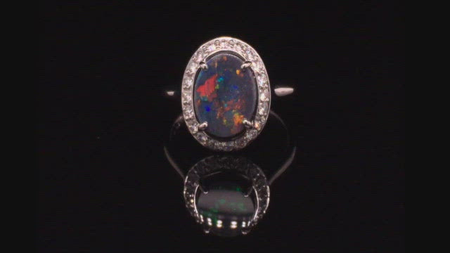 Video of rotating 18K white gold ring with a black opal surrounded with brilliant diamonds on a black background.
