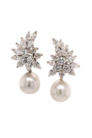 Pearl earrings with a platinum cluster with marquise, pear-shaped, and brilliant-cut diamonds on a white background