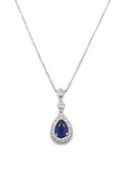 Pear-shaped blue sapphire and diamond necklace in platinum on white background.
