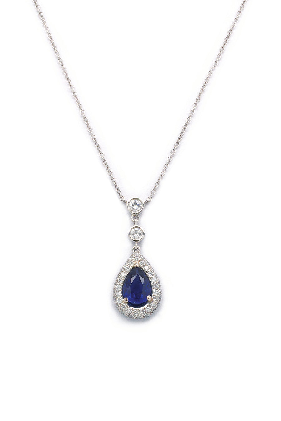 Pear-shaped blue sapphire and diamond necklace in platinum on white background.