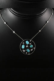 Circular platinum pendant with mosaic motif and Brazilian paraiba cabochons and on a black neck display