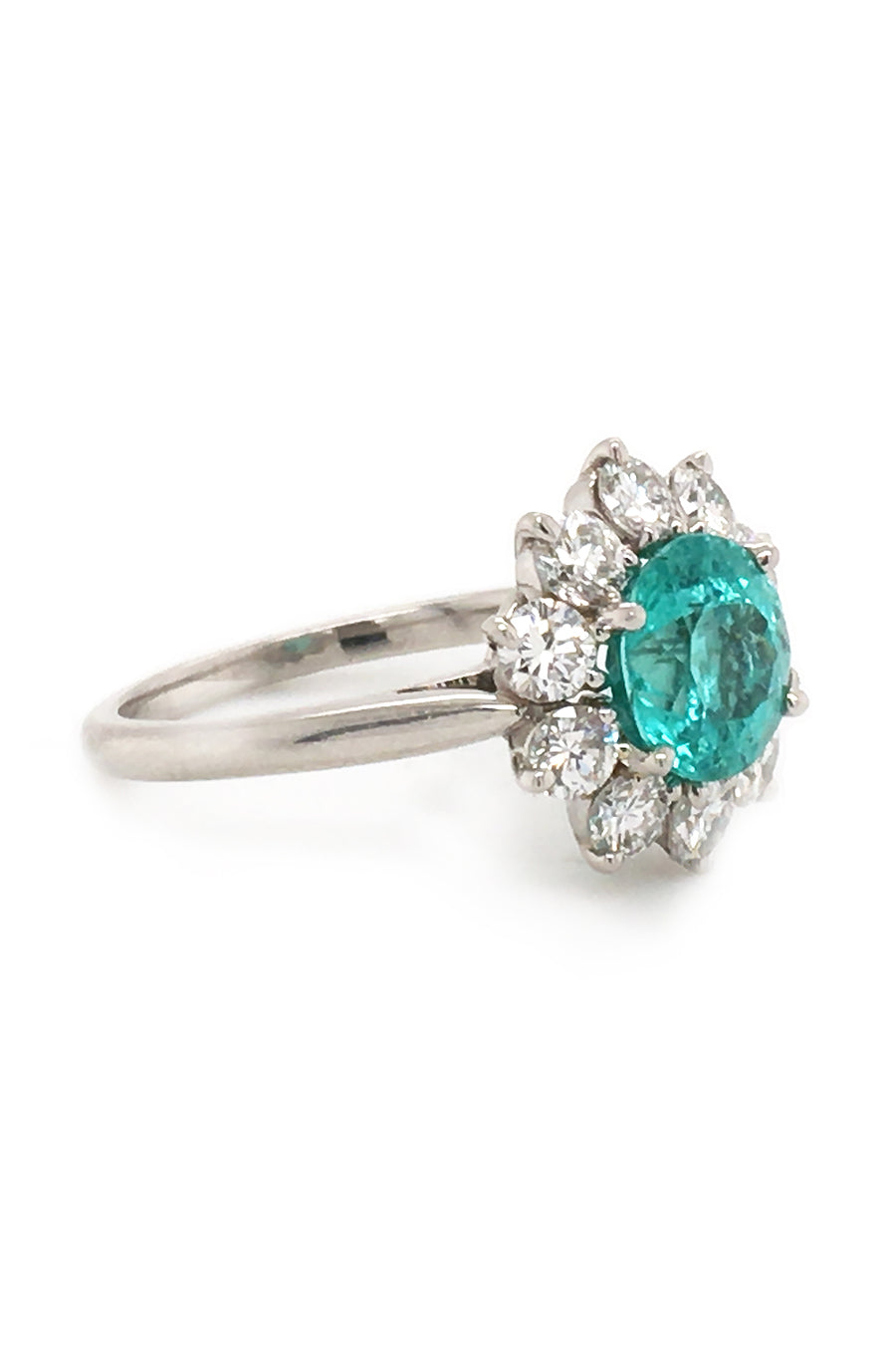 Angle view of platinum ring with paraiba surrounded by diamonds on white background