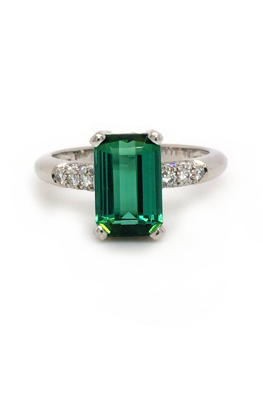 Platinum ring with emerald-cut tourmaline and diamonds on white background