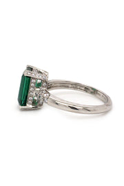 Side view of platinum ring with emerald-cut tourmaline and diamonds on white background