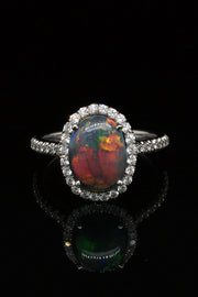 Platinum ring with a black opal and diamonds on a black background