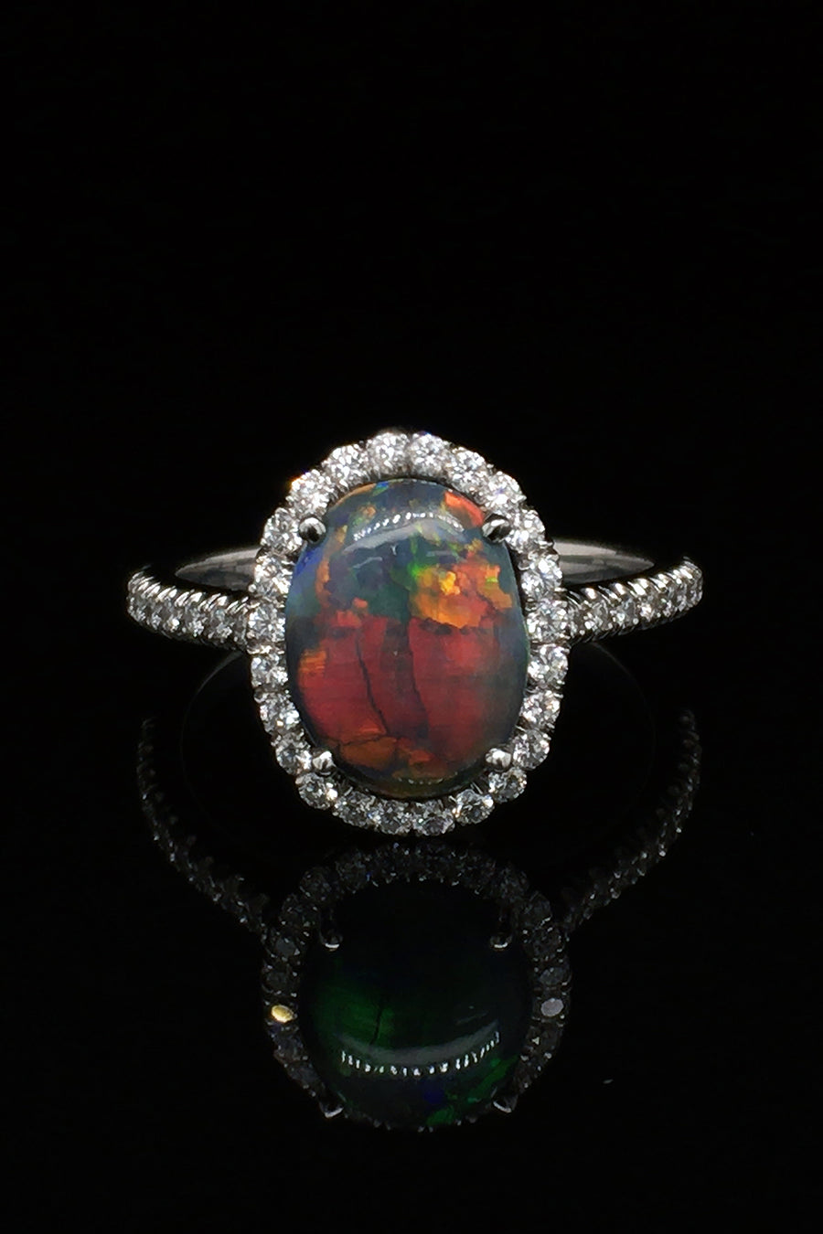 Platinum ring with a black opal and diamonds on a black background