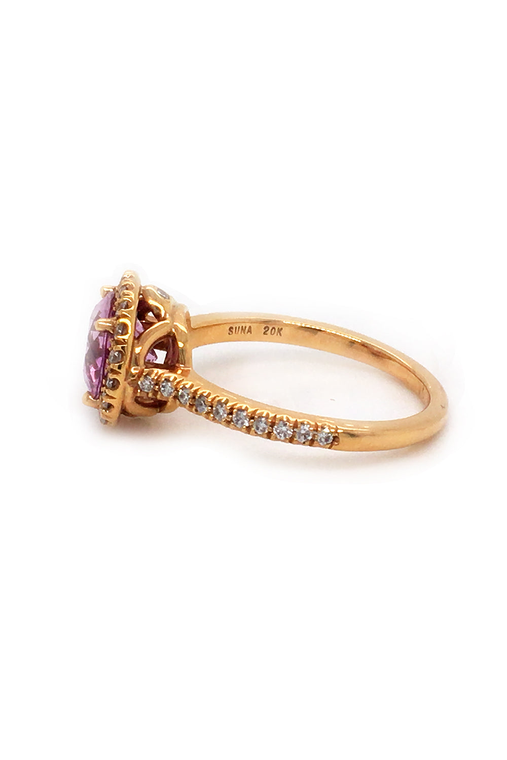 Side view of 20K pink gold ring with pink sapphire and diamond halo on white background