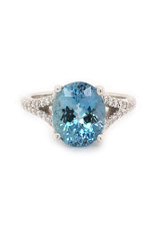An 18K white gold ring featuring an oval aquamarine and diamonds on white background