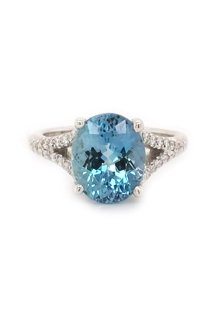 An 18K white gold ring featuring an oval aquamarine and diamonds on white background