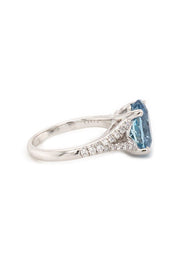 Side view of 18K white gold ring featuring an oval aquamarine and diamonds on white background