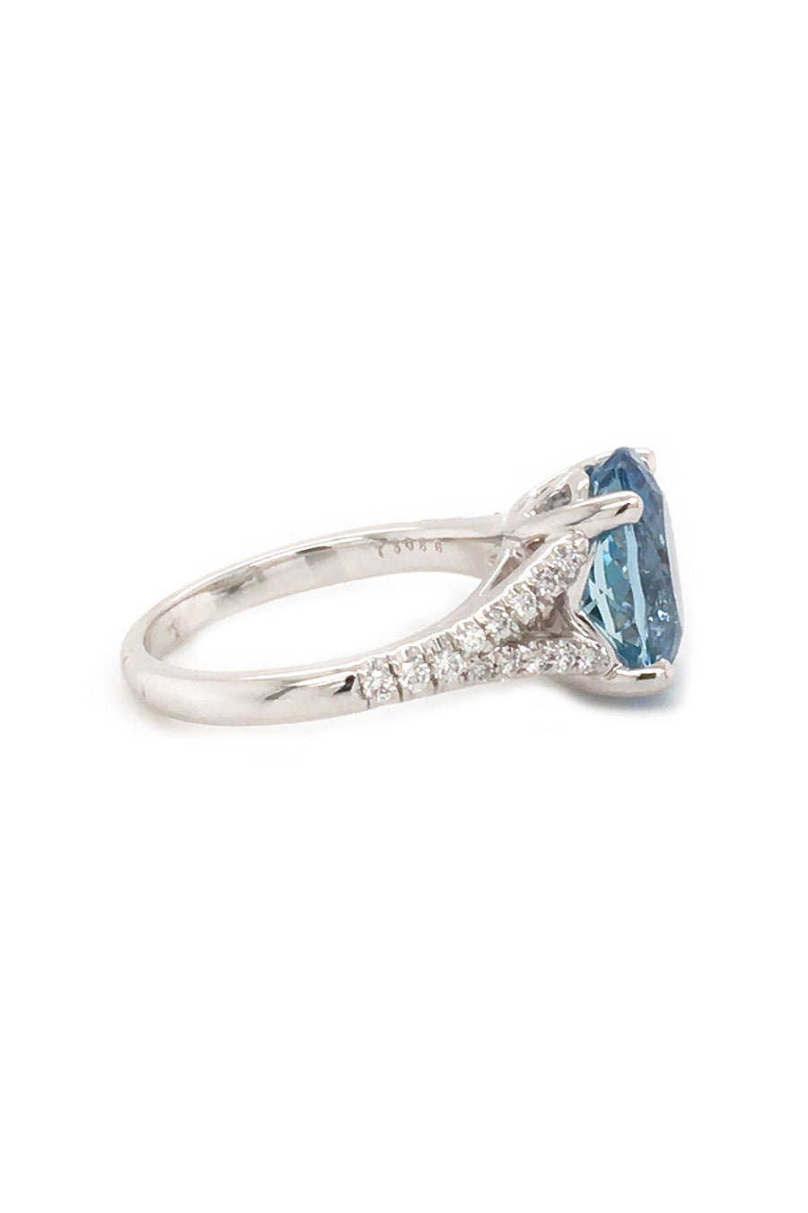 Side view of 18K white gold ring featuring an oval aquamarine and diamonds on white background