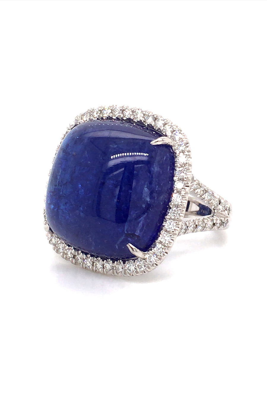 Angle view of 18K white gold ring with a cushion cabochon tanzanite with a diamond halo on a white background