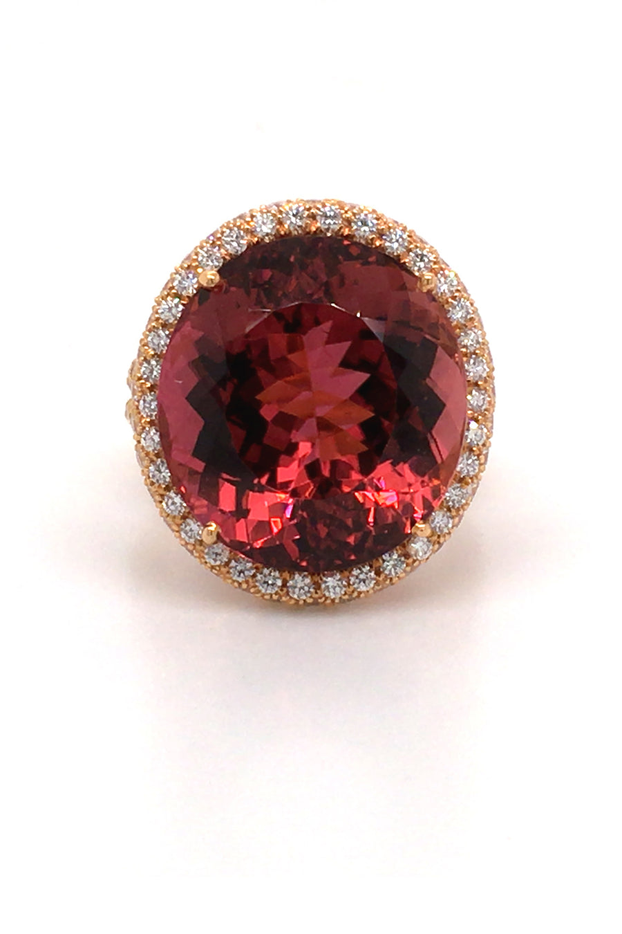 20K pink gold ring with large cinnamon tourmaline with diamond halo on a white back background