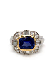 Ring with a blue sapphire in 18K yellow gold with baguettes and brilliant diamonds set in platinum on a white background
