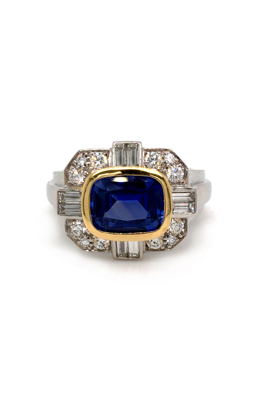 Ring with a blue sapphire in 18K yellow gold with baguettes and brilliant diamonds set in platinum on a white background
