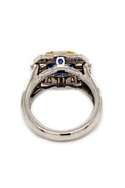 Back view of ring with a blue sapphire in 18K yellow gold with baguettes and brilliant diamonds set in platinum on a white background