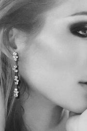 Closeup of woman's ear wearing diamond cluster drop earrings