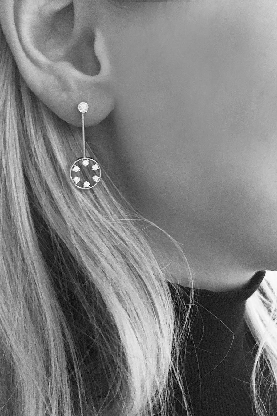 Closeup of woman's ear wearing diamond circle drop earrings