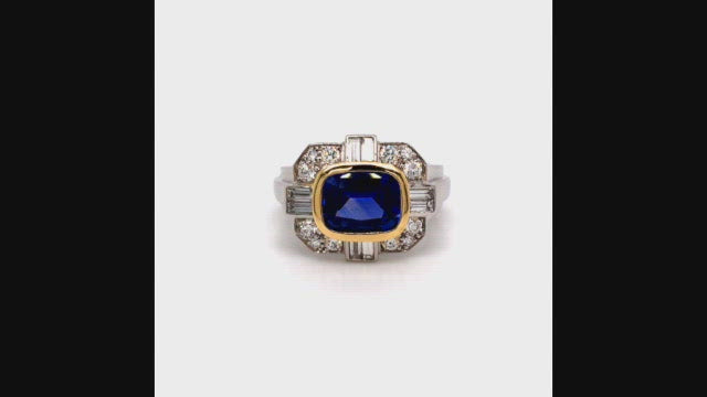 Video of rotating ring with blue gemstone and diamonds on white background