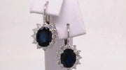 Video of rotating 18K white gold earrings with oval blue sapphires surrounded by diamonds on white background