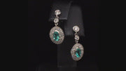 Video of rotating platinum earrings with African paraibas and diamonds on black background
