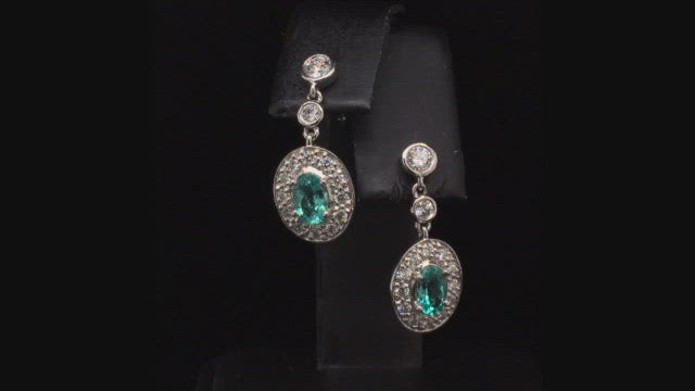 Video of rotating platinum earrings with African paraibas and diamonds on black background