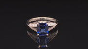 Video of rotating platinum ring with emerald-cut sapphire and diamonds on black background