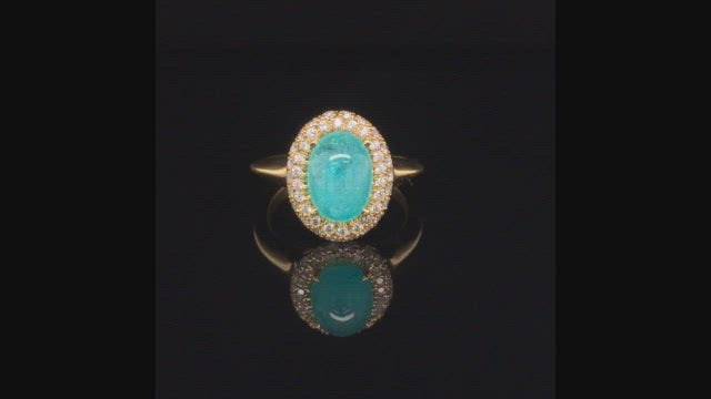 Video of rotating 18K yellow gold ring with oval Brazilian paraiba cabochon and pave diamond halo on a black background.