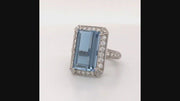 Video of rotating ring with blue gemstone and diamonds on white background