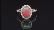 Video of rotating platinum ring with a black opal and diamonds on black background