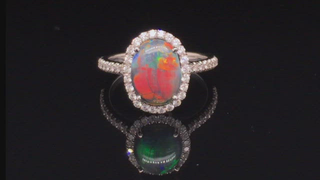 Video of rotating platinum ring with a black opal and diamonds on black background